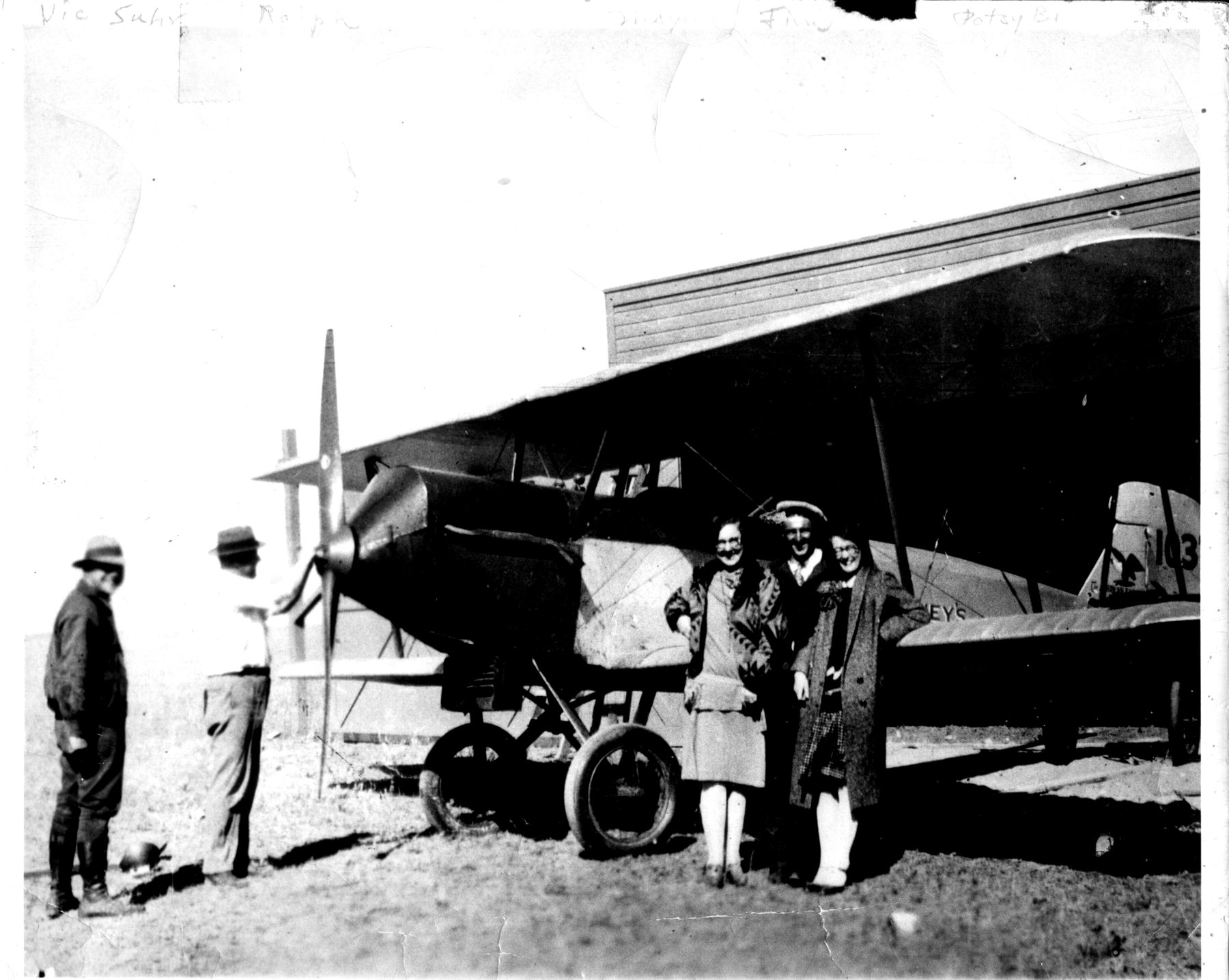 A 1920s biplane at a hangar in Buffalo, Wyoming, with several people standing beside it